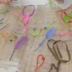 a woven mat made from straws and feathers and string which represents friendship at Quintilian School